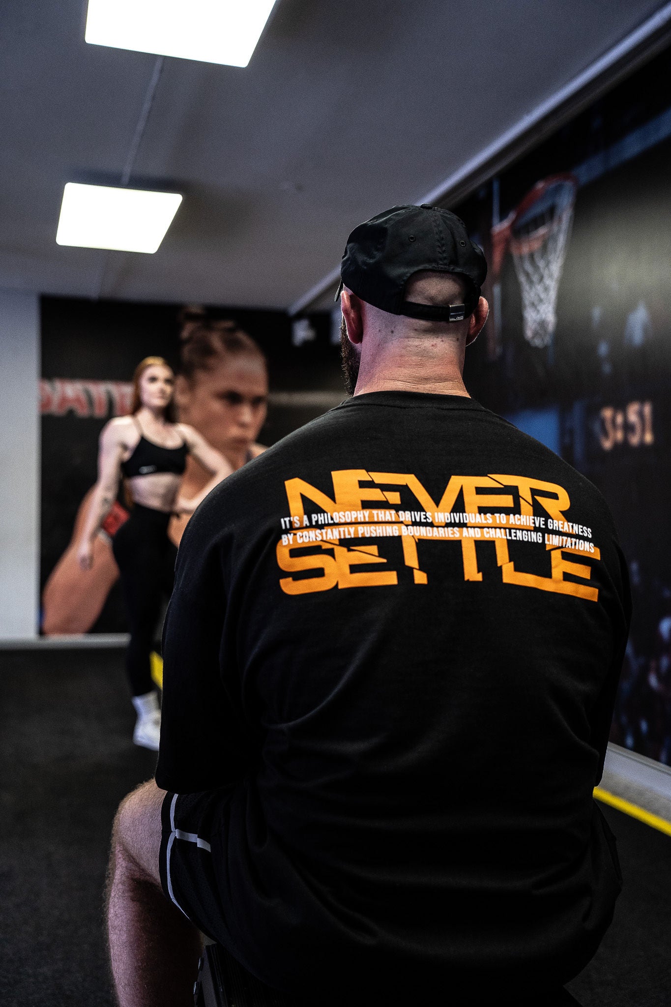 Bodybuilding Coach in posing session with NEVER Settle tee shirt | Trusted by Australian athletes – Shop now at Strom Sports Australia.