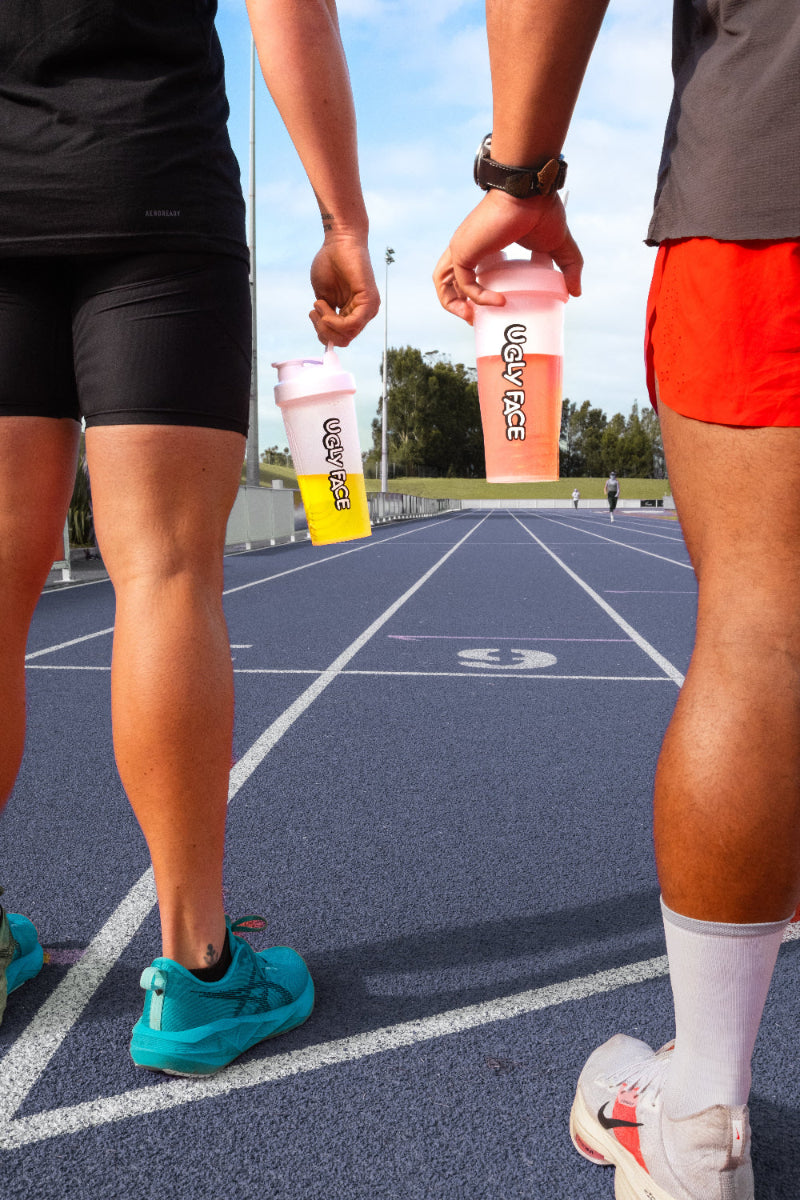 UGLY FACE shakers on athletics track with two runners and electrolytes | Trusted by Australian athletes – Shop now at Strom Sports Australia. Strom AU