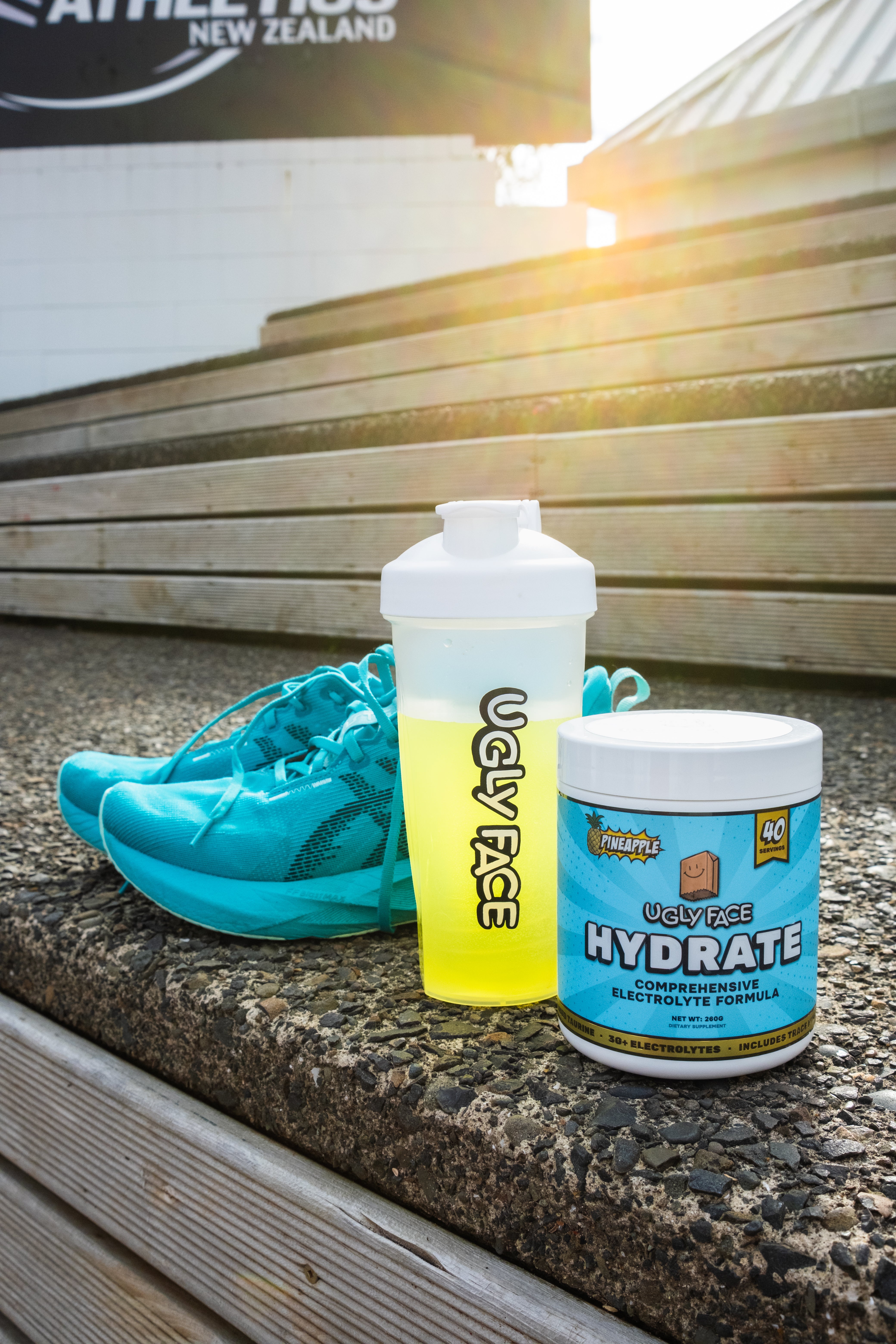 UGLY FACE shakers on athletics track with shoes and UGLY FACE HYDRATE comprehensive electrolyte formula | Trusted by Australian athletes – Shop now at Strom Sports Australia. Strom AU